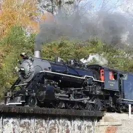 A vintage train on a railway track with views of Missionary Ridge.