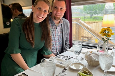 a woman sitting at a table with wine glasses