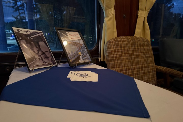 Private events display table featuring framed photos and brochures inside a vintage railcar.