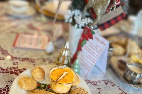 Festive table setting with crackers, dip, and holiday decorations including a small tree and reindeer.