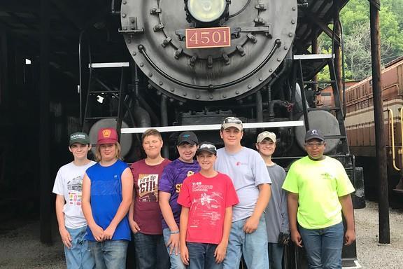 a group of people standing next to a train