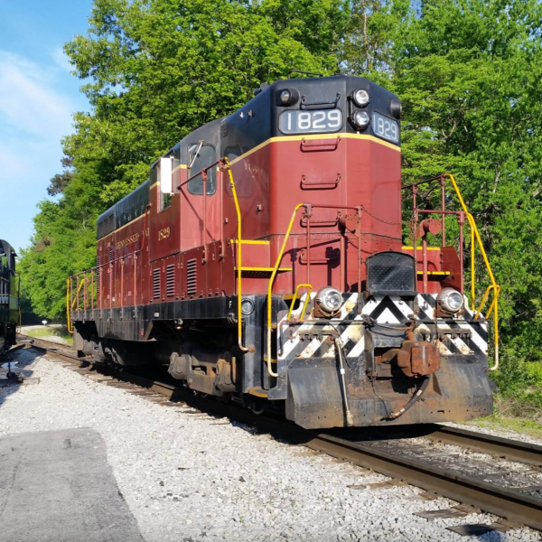 Red diesel locomotive 1829 on sunny tracks.