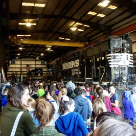 Crowd touring a train maintenance shop