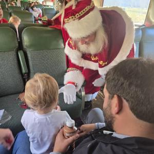 Santa and Mrs. Claus greeting a family aboard Santa’s Hiwassee Train Ride