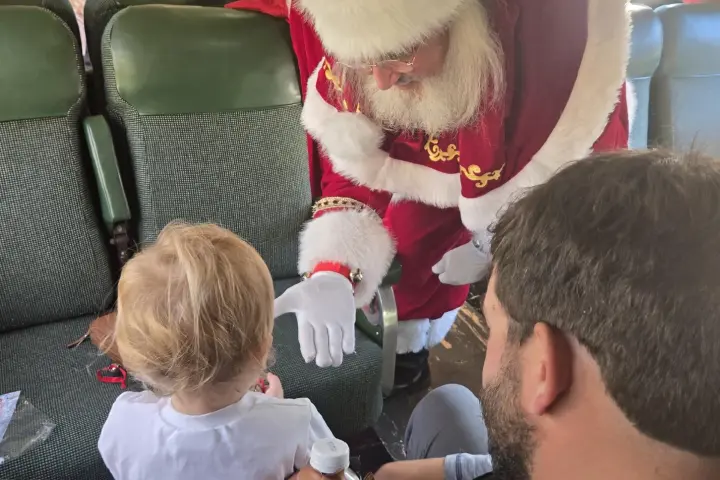 Santa and Mrs. Claus greeting a family aboard Santa’s Hiwassee Train Ride