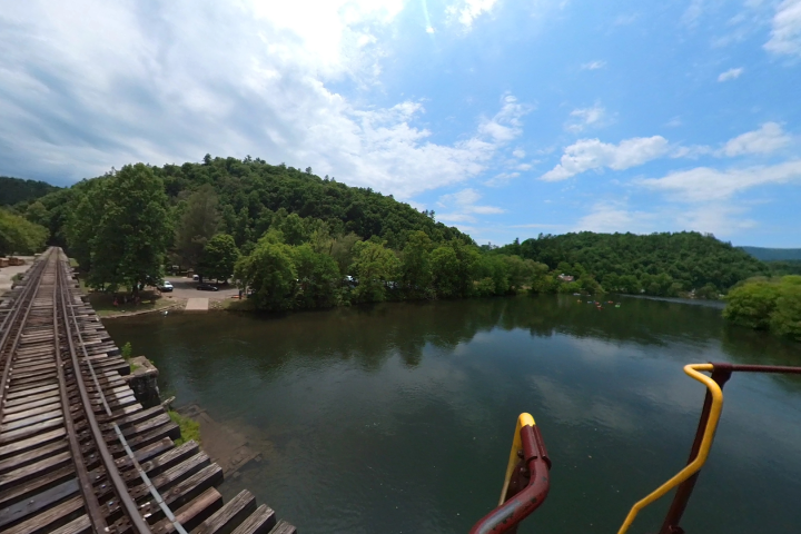 The Hiwassee River Rail Adventure travels down train tracks near a forest, providing a beautiful view for passengers. The experience is perfect for those who love nature and want to enjoy a relaxing journey.
