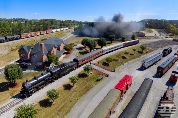 a large long train on a track with smoke coming out of it