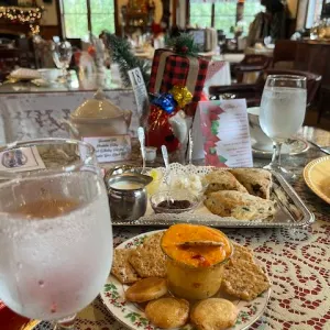 Table set with appetizers, water glasses, and festive decor in a cozy restaurant setting.