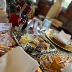 Festive holiday table with snacks, gift decor, and a menu card.