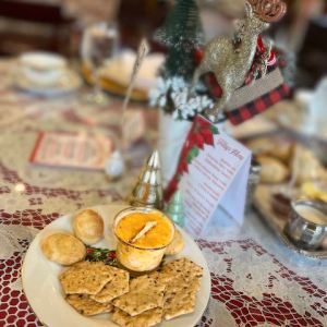 Festive table setting with crackers, dip, and holiday decorations including a reindeer and tree.