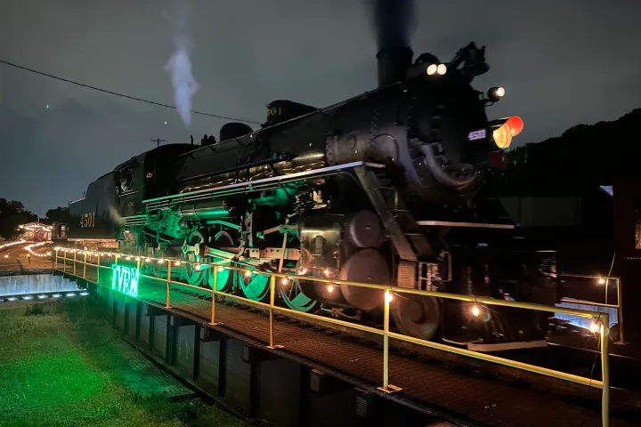 a steam train on the tracks at night