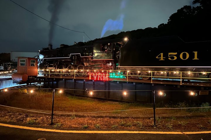 a large long train on a train track at night