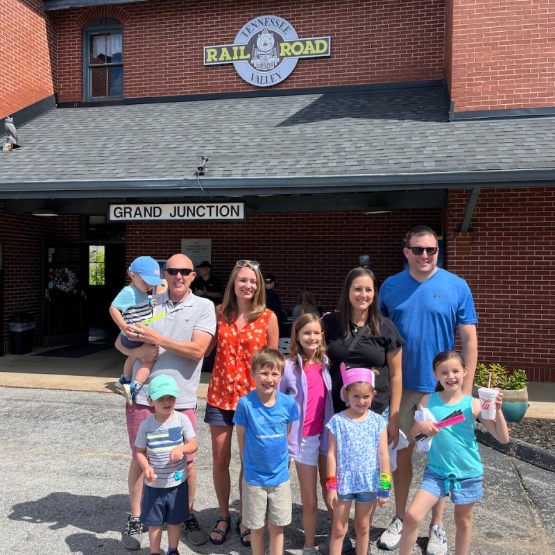 a group of people standing in front of a brick building