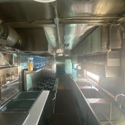 The transformation is evident in the photos, showcasing the installation of a custom 3-compartment sink, 3-bay steam tray, brand-new stoves and gas piping, modern refrigeration units, expanded counter space, dish racks, and enhanced storage for supplies.