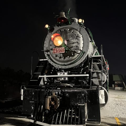 Steam locomotive 4501 at night with headlight on, emitting steam.