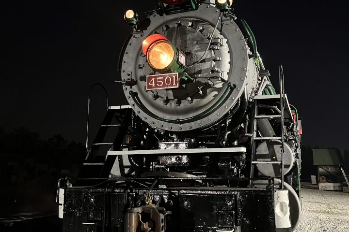 Steam locomotive 4501 at night with headlight on, emitting steam.