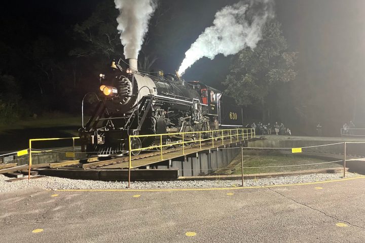 a steam train on a track with smoke coming out of it