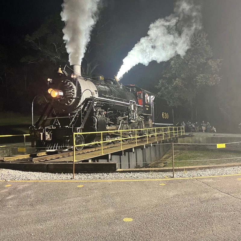 a steam train on a track with smoke coming out of it