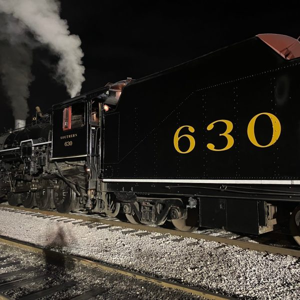 a steam train on a track with smoke coming out of it