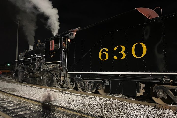 a steam train on a track with smoke coming out of it