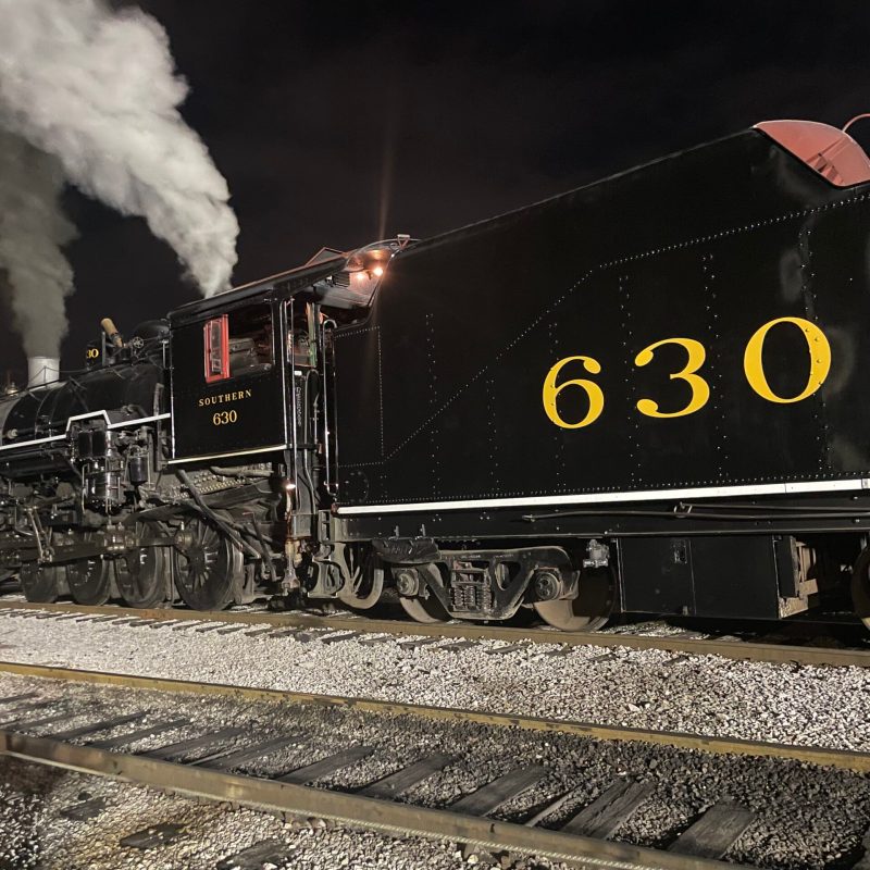 a steam train on a track with smoke coming out of it