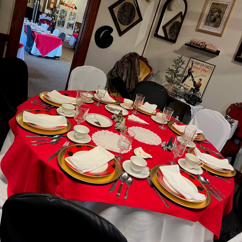 a group of people sitting at a table with a cake