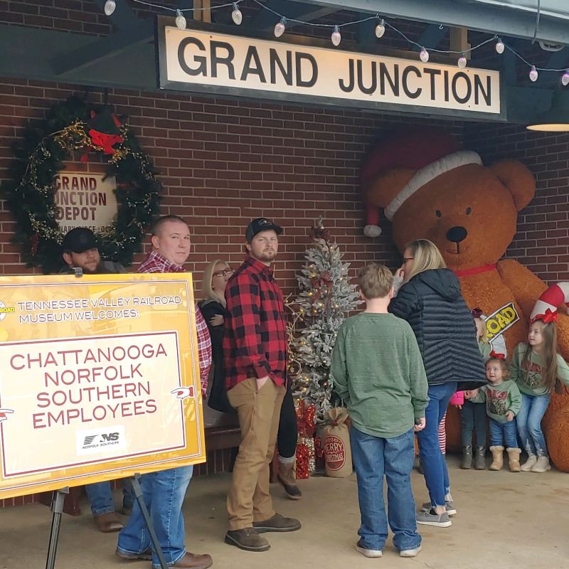a group of people standing in front of a sign