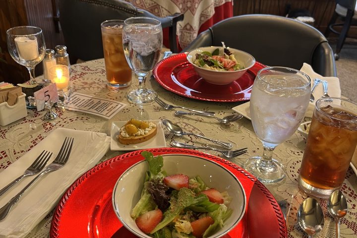 a plate of food and glasses of beer on a table
