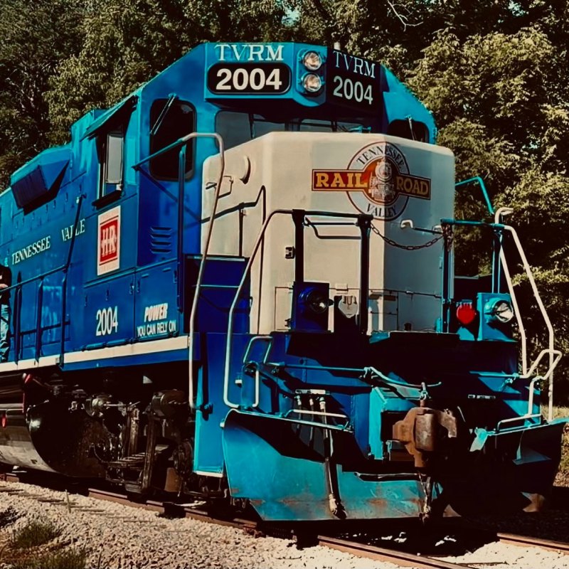 a blue train traveling down train tracks