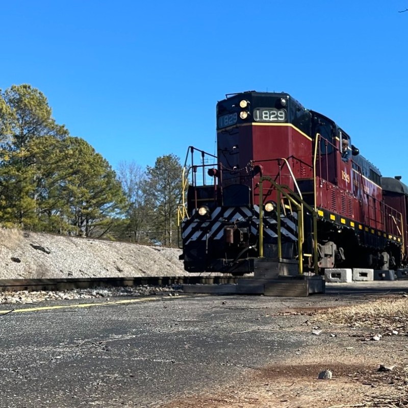 Tennessee Valley Railroad Engine 1829 departing from Grand Junction station on a clear day.