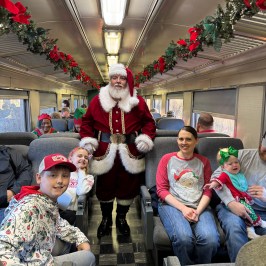 Santa visiting families inside a decorated Summerville holiday train.