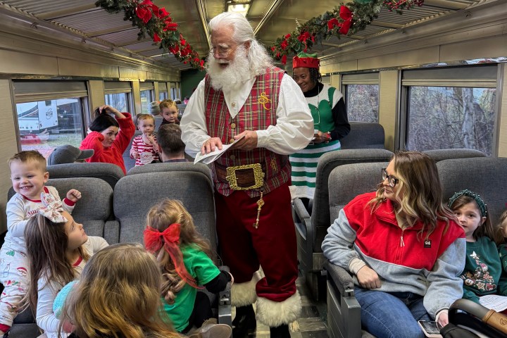 Santa Claus greeting children aboard a festively decorated Summerville Santa Special train