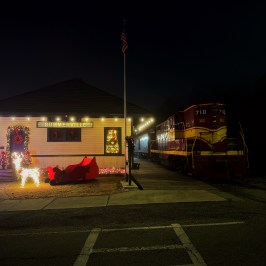 Summerville train depot at night decorated with Christmas lights and festive holiday displays.