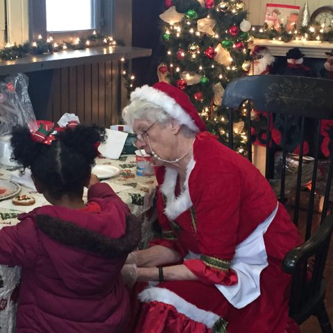 Santa Claus speaks with young riders aboard the Summerville Santa Special holiday train.