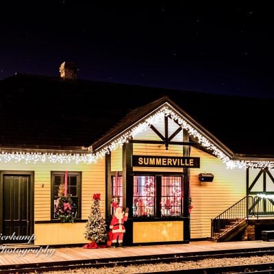 Summerville Depot decorated for Christmas with festive lights and Santa display at night