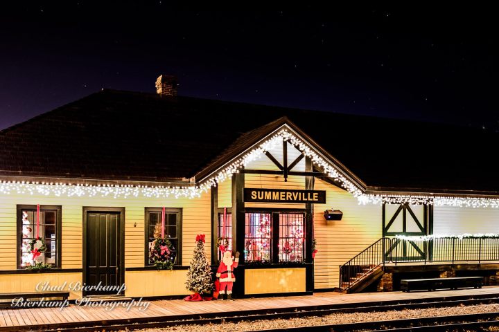Summerville Depot decorated for Christmas with festive lights and Santa display at night