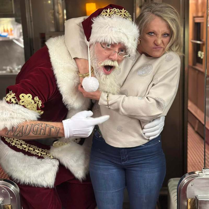 Santa playfully hugs a guest aboard the NightCaps With St. Nick holiday ride.