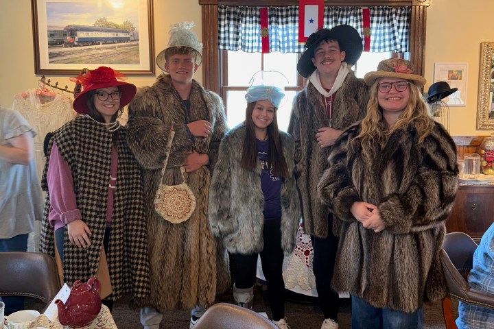 Guests dressed in vintage winter attire inside the Homefront Tea Room during Christmas Tea at TVRM.