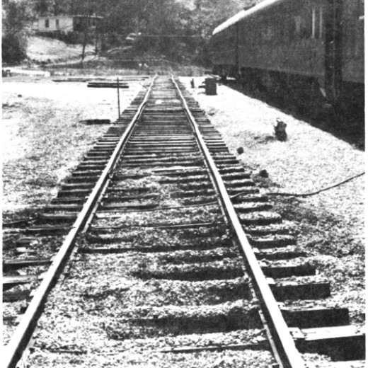 Historic black-and-white photograph of railroad tracks leading past a depot building during early development at the Tennessee Valley Railroad Museum.