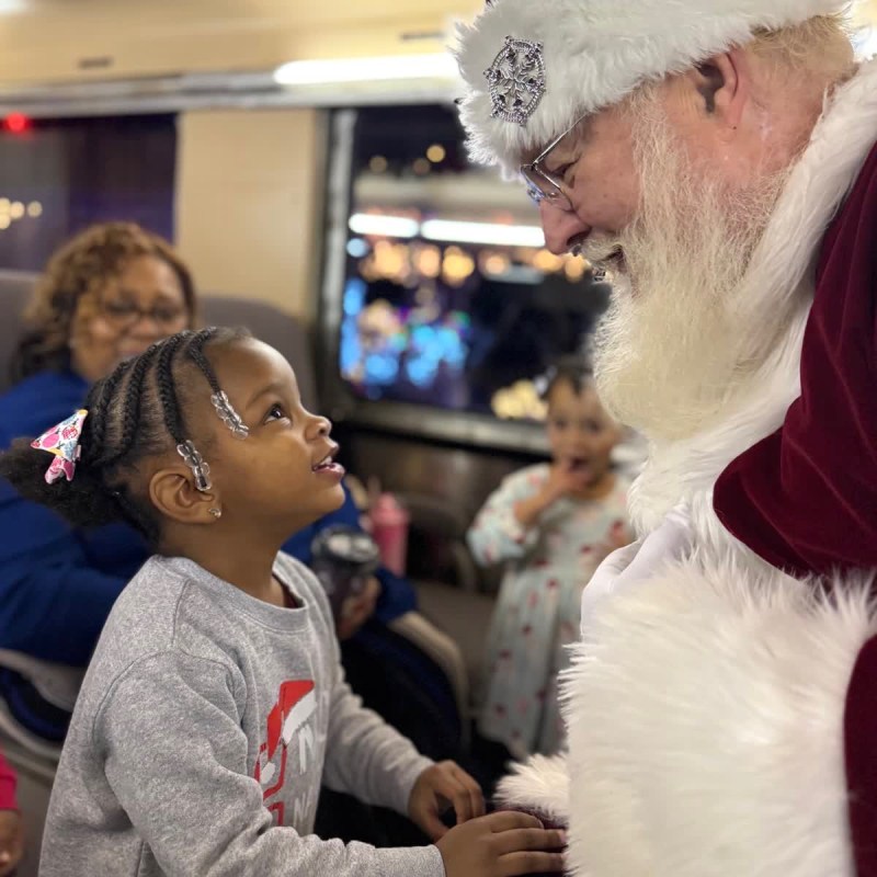 Child excitedly talking with Santa aboard a Tennessee Valley Railroad Museum Christmas train