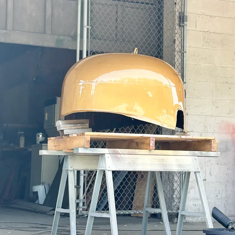 Large yellow dome on wooden supports in a workshop.