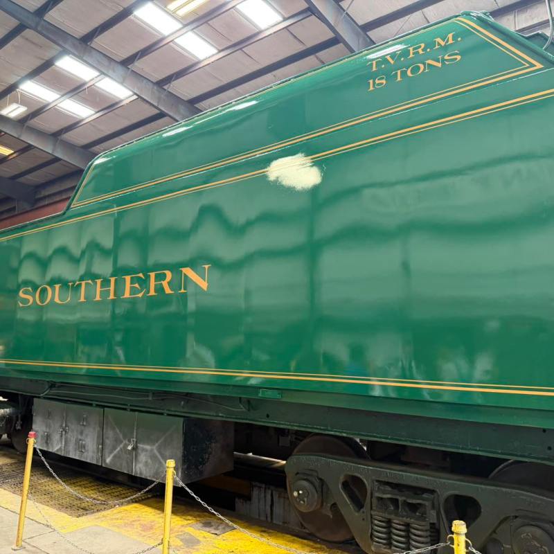 Green train car with 'SOUTHERN' label in a workshop.